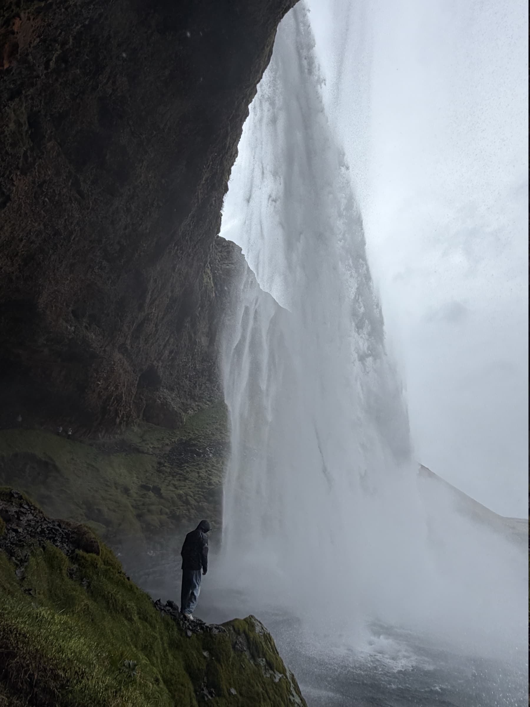 Rohan standing behind a waterfall in Iceland
